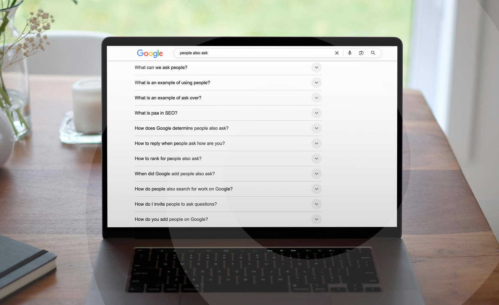 A laptop displays Google search results for "People Also Ask" and related questions